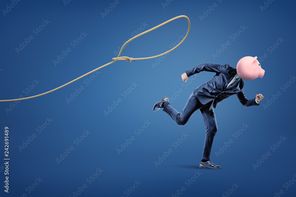 Businessman with piggy bank head running from loop on the blue background Businessman with piggy bank head running from loop on the blue background