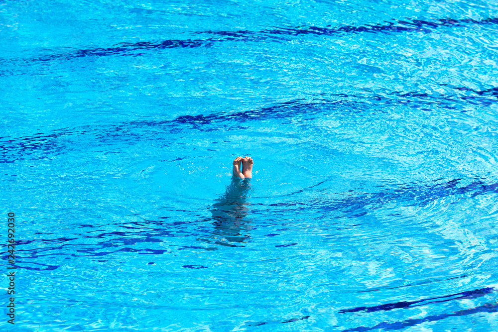 Naklejka Feet of woman doing a handstand inside swimming pool