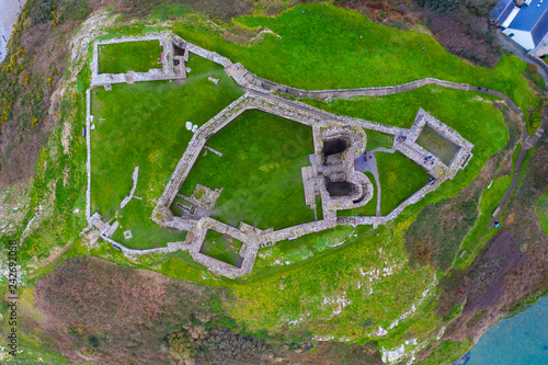 Aerial view over Criccieth Castle on a rocky peninsula overlooking Tremadog B...