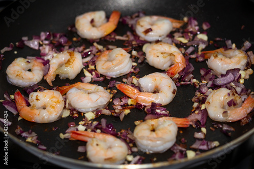 hot pan with shrimps with red onions and garlic