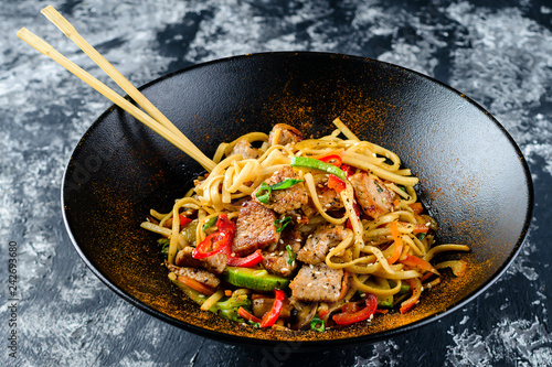 Udon stir-fry noodles with chicken meat and sesame in bowl