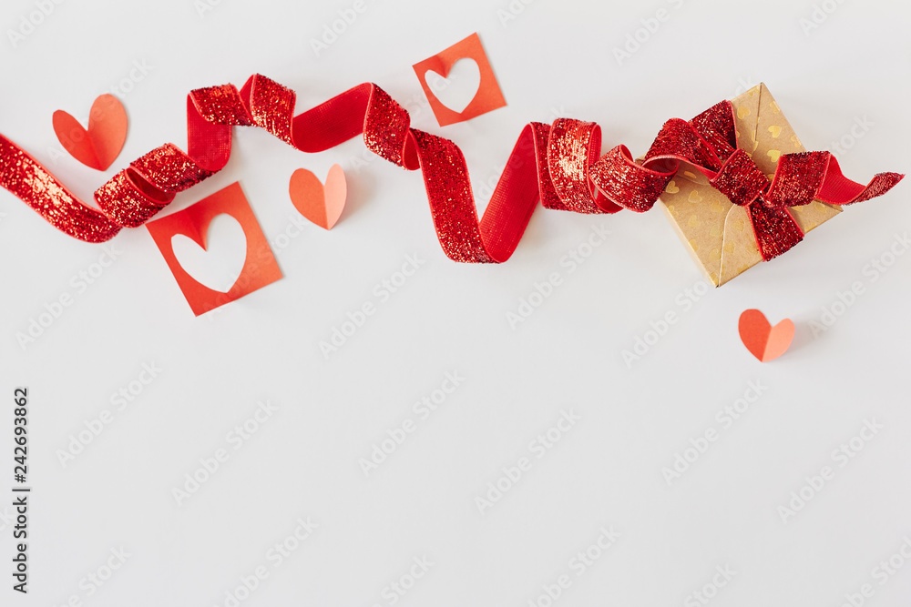 Gift box with red ribbon and red paper hearts on white background. Valentine's day, love, holiday present concept Gift box with red ribbon and red paper hearts on white background. Valentine's day, love, holiday present concept