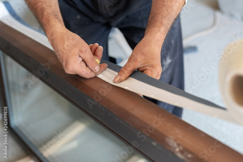 Man using white protective type and glue in on window frame