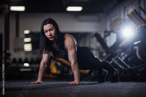 Fototapeta Naklejka Na Ścianę i Meble -  athletic woman doing push-ups in the gym. Woman doing yoga