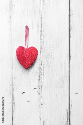 Valentine's Day. Red heart on a white wooden rustic background from boards. Top view, flat lay, copy space.Vertical frame