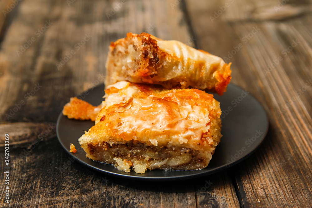Baklava - homemade pie with walnuts on old wooden table Baklava - homemade pie with walnuts on old wooden table