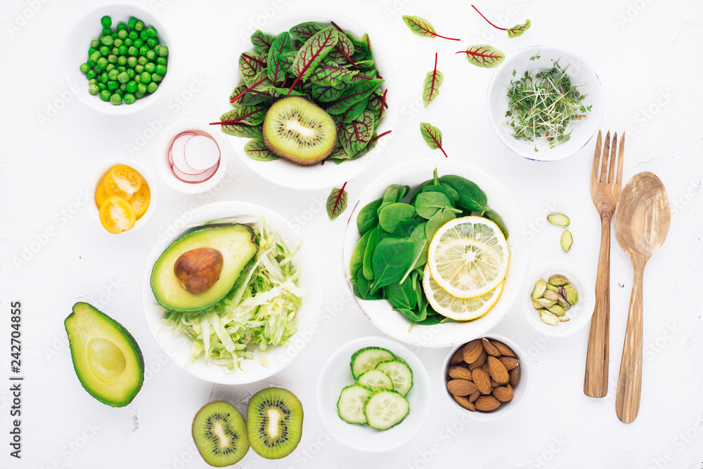 Green ingredients for spring detox salads: spinach, sorrel with red veins, cucumbers, radishes, iceberg lettuce, green peas, avocados, lemon, microgreen, yellow tomatoes on a white background with Green ingredients for spring detox salads: spinach, sorrel with red veins, cucumbers, radishes, iceberg lettuce, green peas, avocados, lemon, microgreen, yellow tomatoes on a white background with