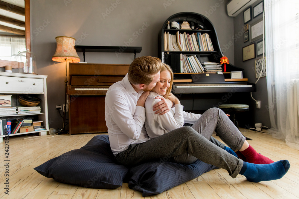 Obraz premium Loving young couple sitting on the floor in the room