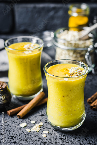 Oatmeal turmeric smoothie on dark background. Selective focus, space for text.