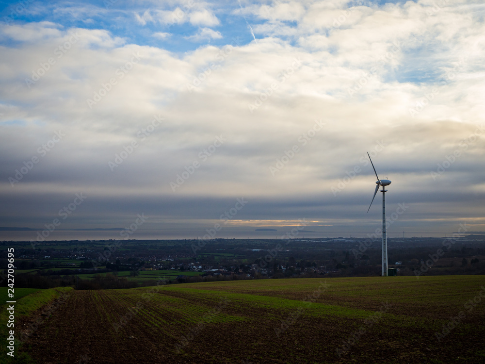 Obraz premium Alternative energy source. Rural landscape farm with a single windmill turbine near Cardiff, Wales UK