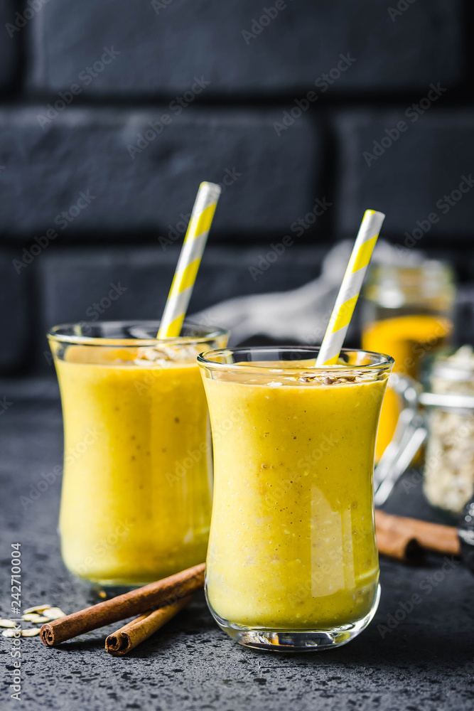 Fototapeta premium Cinnamon ginger turmeric smoothie on dark background. Selective focus, space for text.