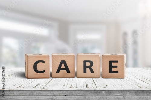 Care sign on a white table in a bright room