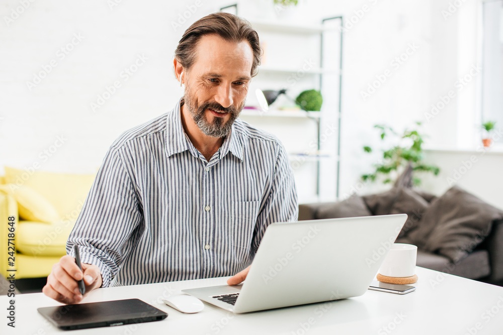 Waist up of cheerful man working at home and smiling