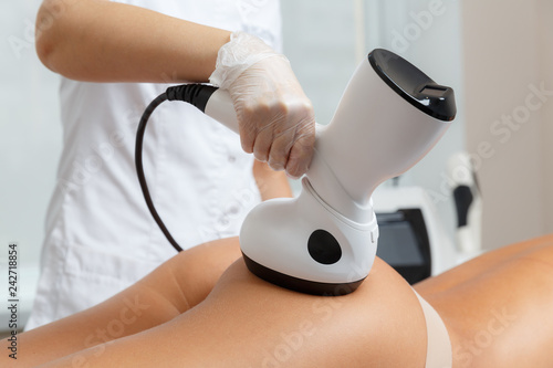 Fotografie Cosmetologist making radio waves lifting therapy procedure for hips and but