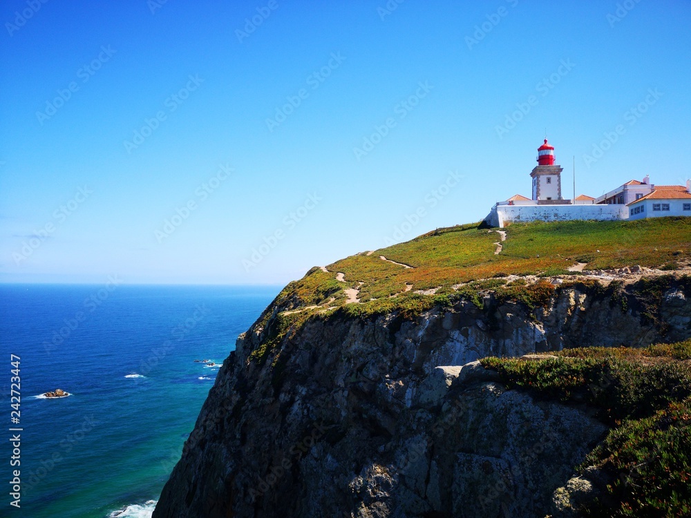 Lighthouse on cliff with a green background
