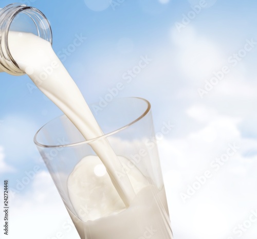 Glass jug of fresh milk on background