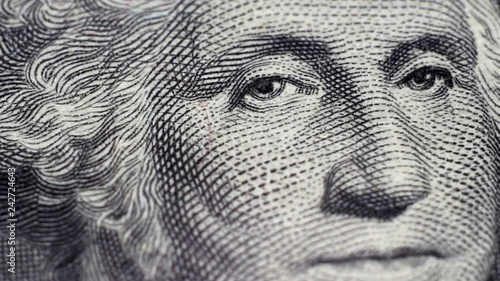 Tracking macro of George Washington's face on the US one dollar bill.
