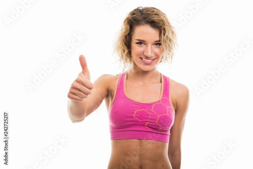 Portrait of beautiful young fit girl showing thumb up