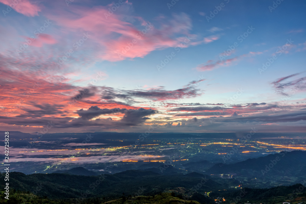 High view beautiful nature landscape of colorful sky during the sunrise see the lights of the road and city at Phu Thap Berk viewpoint famous tourist attractions of Phetchabun Province, Thailand