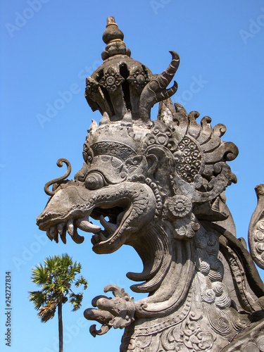 Illusion of a giant hindu dragon eating a palm tree  street ornament in Bali  Indonesia