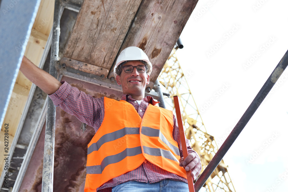 portrait smiling construction manager / architect on site during the construction of a house - planning and control on site portrait smiling construction manager / architect on site during the construction of a house - planning and control on site