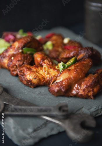 Wallpaper Mural A beautiful platter slate plate full of organic delicious golden and crispy bbq chicken wings, served in a dark photography mechanic style environment. Surrounded by mechanic tools. food fashion. Torontodigital.ca