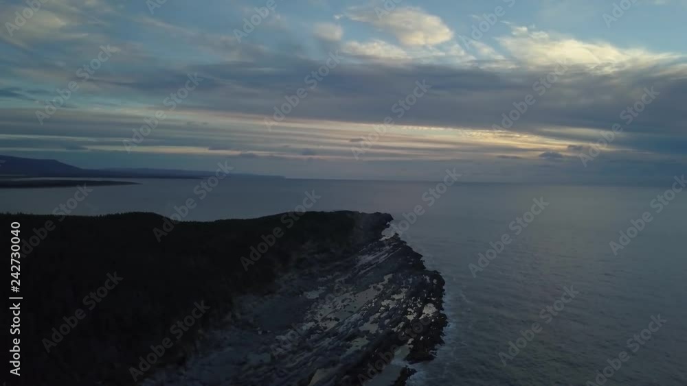 Aerial view of a rocky shore on the Atlantic Ocean Coast during a vibrant sunny sunset. Taken in Cow Head, Newfoundland, Canada. Aerial view of a rocky shore on the Atlantic Ocean Coast during a vibrant sunny sunset. Taken in Cow Head, Newfoundland, Canada.