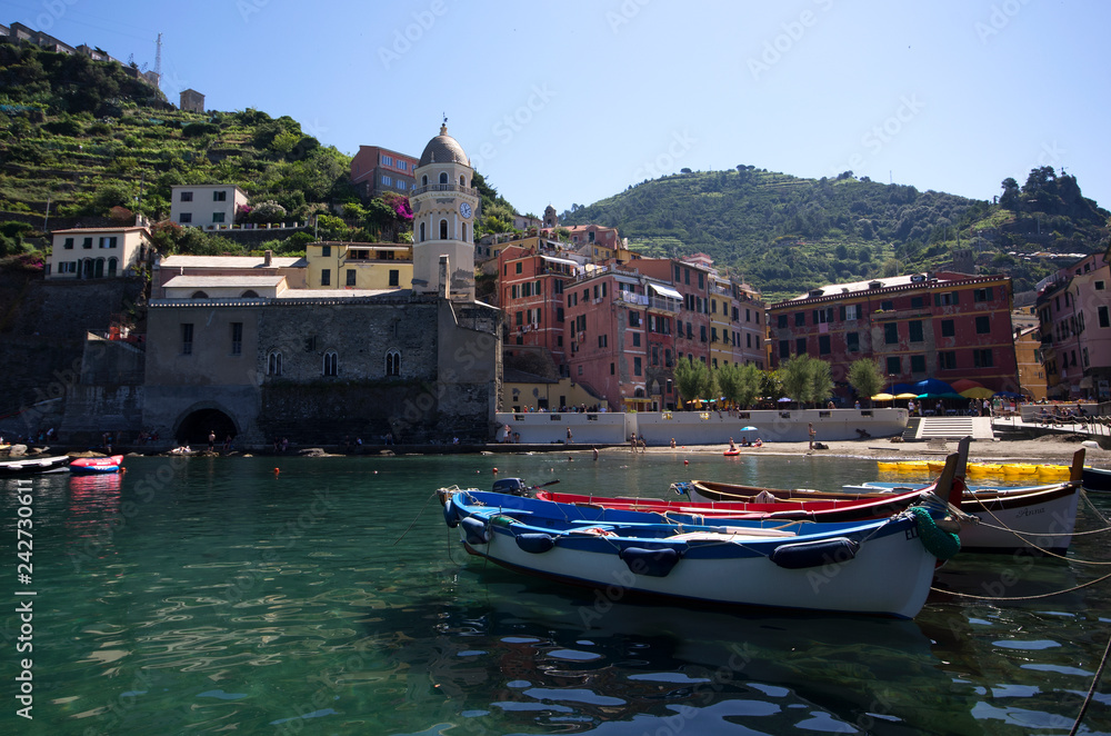 Vernazza, Liguria / Italy - June 23 / 2016: Boats and the clock tower at Vernazza