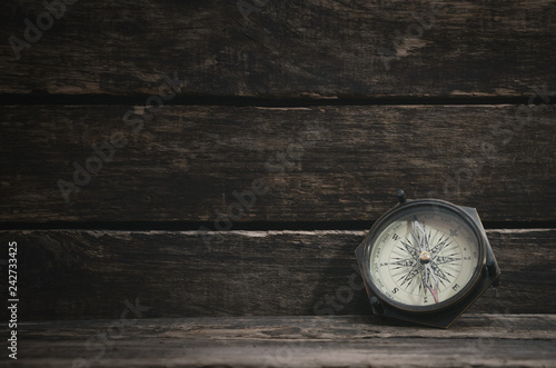 Compass on the wooden table background with copy space. Travel concept.