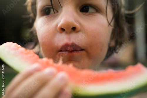 Close up of boy eating a watermelon slice photo