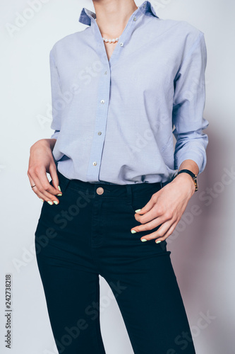 Elegant young woman dressed in black skinny jeans