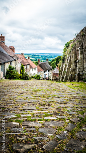 Old limestone English houses at Gold Hill in Shaftesbury is an authentic place in the South of the UK. English countryside in Dorset. Photo with selective focus. photo