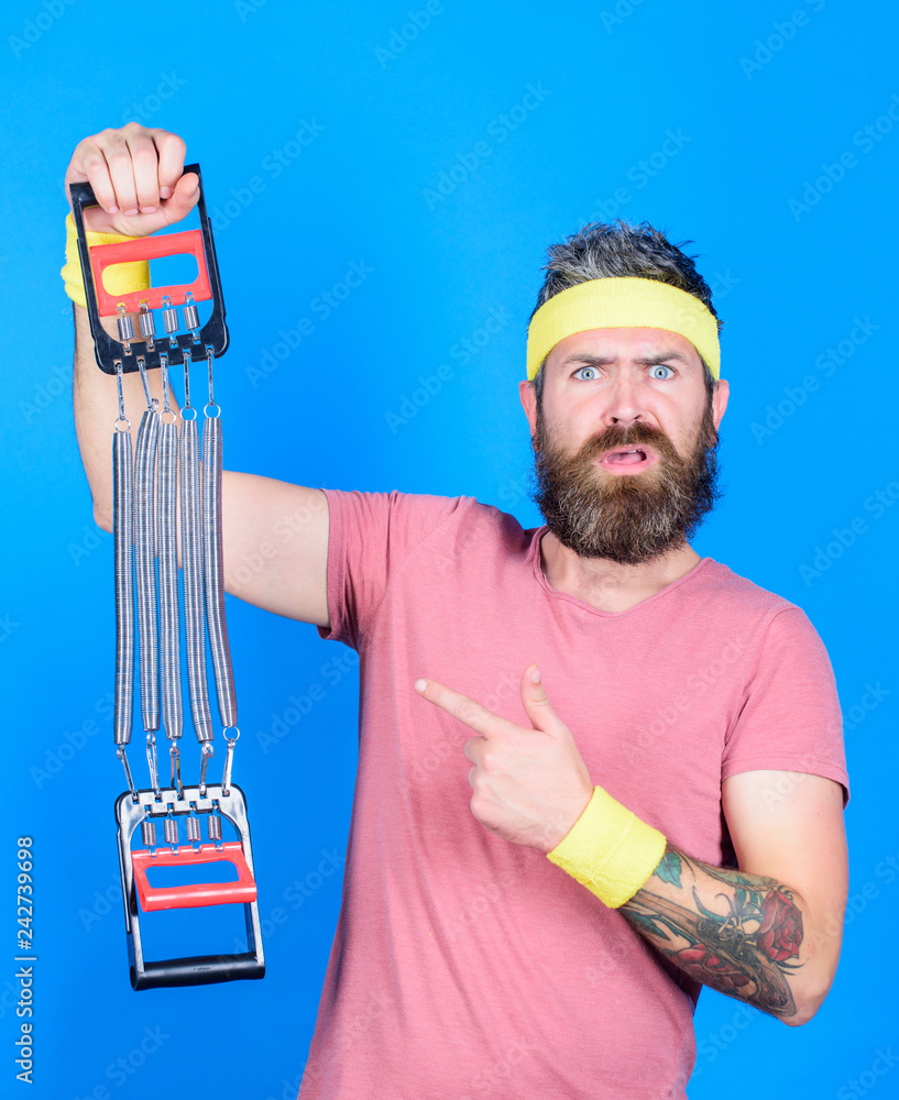 Athlete workout with expander. Sportsman training stretching expander. Man bearded athlete