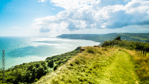 Green pathway / Trekking path on hills in English holiday countryside near Charmouth. British summer holidays by the sea / English Channel.  Golden Cap on jurassic coast in Dorset, UK. Selective focus