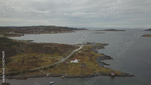 Aerial view of a small town on a rocky Atlantic Ocean Coast during a cloudy day. Taken in Quirpon, Newfoundland, Canada. photo