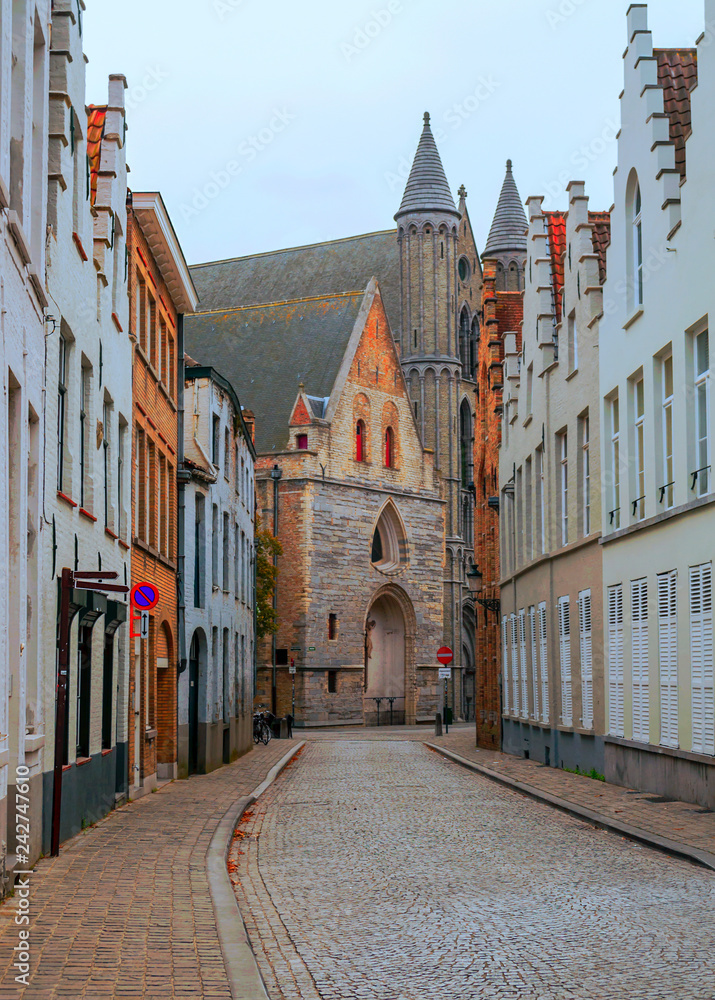 Streets of Bruges in Belgium with its medieval style facades on a cloudy day.
