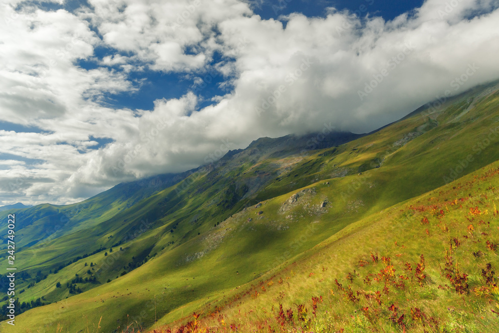 Meadow on mountain of Arkhyz. The beautiful summer landscape with cloudy sky and Caucasus mountain. Mountain range scenic landscape.