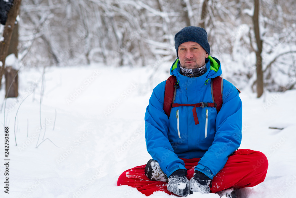 Happy man, traveler relaxing meditating in the winter forest Happy man, traveler relaxing meditating in the winter forest
