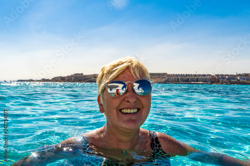 Frau schwimmt im Meer und lächelt blauer Himmel Sonnenschein