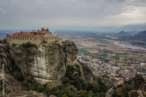 christian religion lonely monastery on top of steep rock on dramatic cloudy country side landmark landscape background view