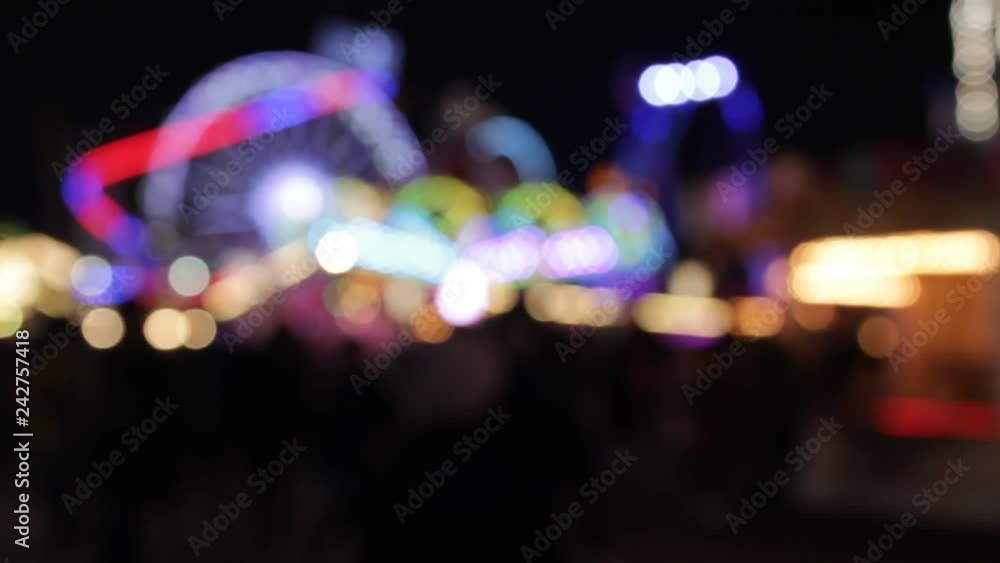 funfair fairground ride rainbow bokeh lights rides moving flashing people at night funfair fairground ride rainbow bokeh lights rides moving flashing people at night
