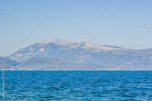 sea vivid blue water south Europe scenic nature landscape with foggy mountain ridge horizon silhouettes background 