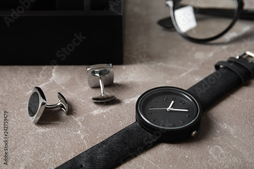 Stylish wrist watch and cuff links on table. Fashion accessory