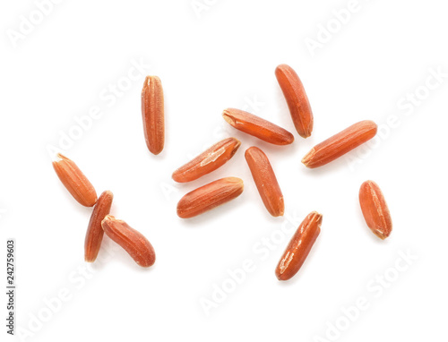 Scattered grains of brown rice on white background, top view