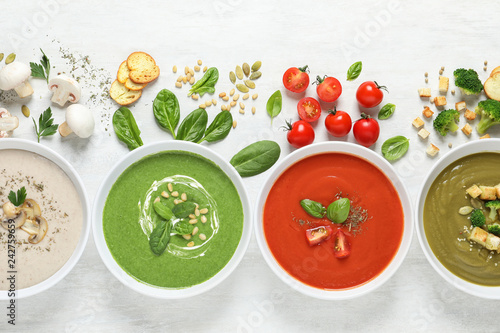 Flat lay composition with various soups and ingredients on white background. Healthy food