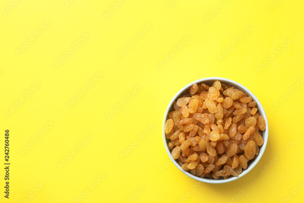 Bowl with raisins and space for text on color background, top view. Dried fruit as healthy snack Bowl with raisins and space for text on color background, top view. Dried fruit as healthy snack