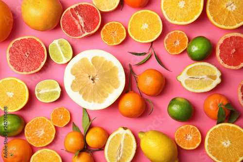 Different citrus fruits on color background  top view