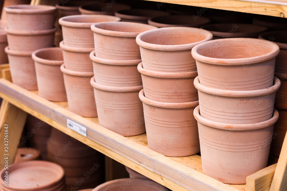 Stacks of clay pots for sale on a shelf in a store. Stacks of clay pots for sale on a shelf in a store.