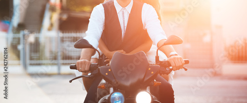 Young couple ridind motorcycle at sunset in city. photo