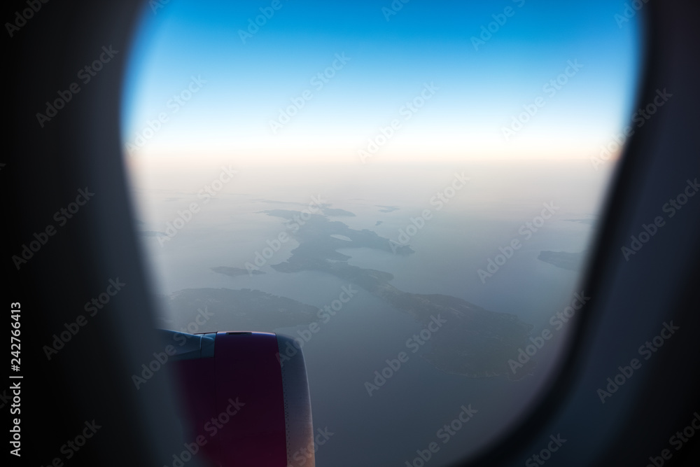 View from the window to airplane engine. Above the sea in sunny day.